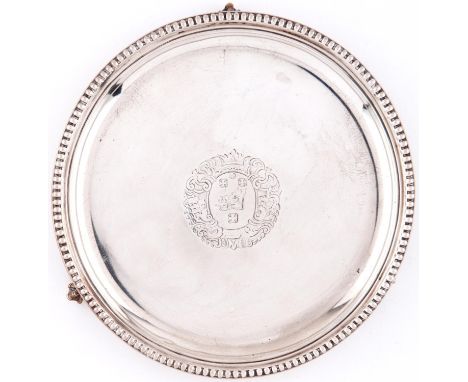 A Victorian silver waiter, with plain cavetto and beaded rim, the field engraved with armorials and mantling, on three claw a