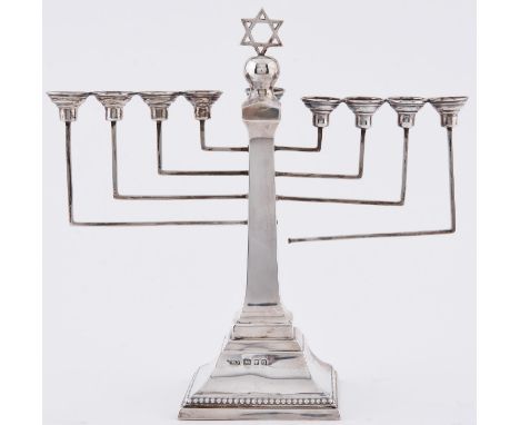 Judaica. A George V silver menorah, on flared square foot, 26.5cm h, by A Taiteldaun &amp; Co, London 1933, 11ozs 14dwts  One