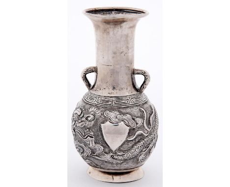 A Chinese silver repousse dragon vase, late 19th c, the plain flared cylindrical neck with two angled handles, on flared foot