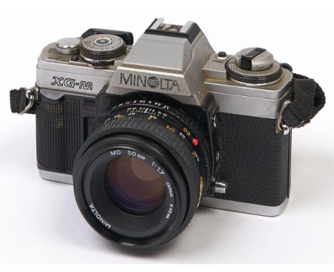 A Minolta XG-M SLR 35mm camera, with Minolta MD 50mm F1.7 lens  In apparently working order, wear consistent with age, lens w