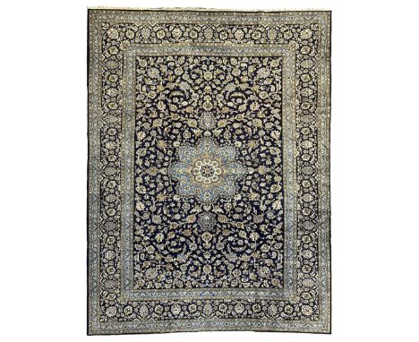 Central Persian Kashan indigo ground carpet, central lighter blue floral medallion surrounded by interlacing leafy branches a