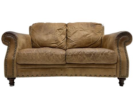 Two-seat club sofa, rolled arms upholstered in tan leather with stud work bands, on turned feet Dimensions: Height:&nbsp;81cm