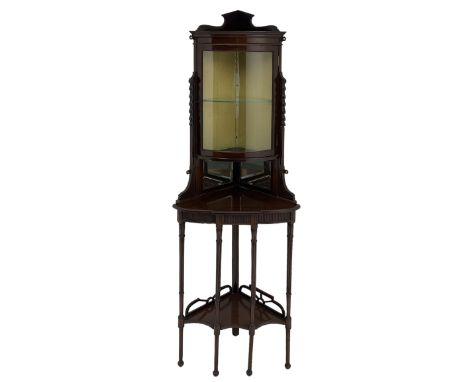 Edwardian mahogany floor-standing corner cabinet, cylinder glazed door above mirror backed shelf, the lower tier with fretwor