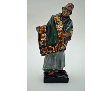 Glazed Porcelain Decorated by the Artists of The Royal Doulton Studios. Featuring the "Carpet Seller." Mold 219. Artist signe