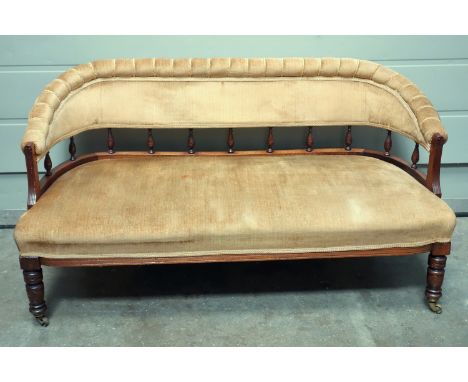 Edwardian walnut salon sofa with a spindle and upholstered ribbed back and seat, on turned legs and castors, W 134.5cm 