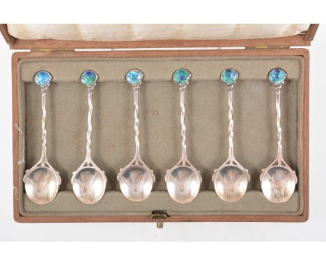 Archibald Knox for Liberty & Co., a cased set of six 'Cymric' silver and enamel teaspoons, 1905, with twisted shafts terminat