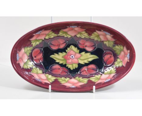 A Moorcroft Pottery dish, oval form, tropical flowers and fruit against a maroon ground, Moorcroft Collectors Club item, fact