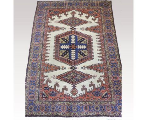 A Persian carpet, with a central hooked medallion, on a blue ground, 310 x 217cm