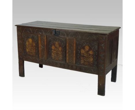 A 17th century carved oak and marquetry coffer, of panelled construction with a hinged lid, each panel inlaid with a stylised