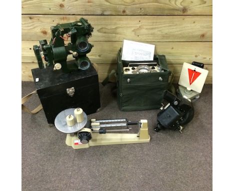 A geiger counter, in a canvas case, together with three various surveyor's instruments and a set of scales