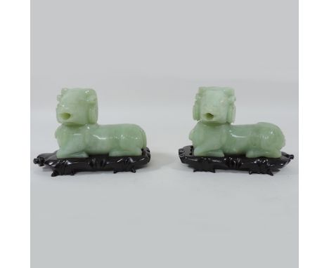 A pair of celadon jade coloured hardstone incense burners, in the form of rams, on carved hardwood stands, 13cm tall overall
