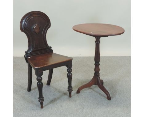 A Victorian carved mahogany hall chair, with a shield shaped back, together with an occasional table, on a tripod base