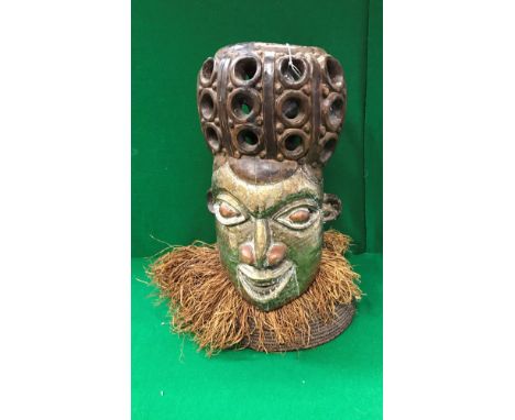 A 20th Century West African carved hardwood and brass and copper embellished helmet mask with grass ring to base (bears label