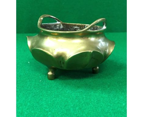 A Chinese bronze censer of small proportions with lotus leaf design raised on three plain feet bearing six character Qianlong