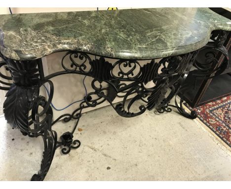 A wrought iron console table in the Rococo style black painted with green marble top