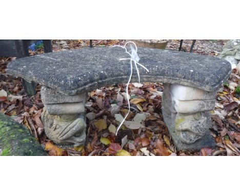 A reconstituted stone garden bench of crescent form