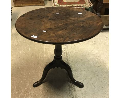 A George III mahogany tea table, the circular snap top on a turned pedestal to cabriole tripod base and pad feet