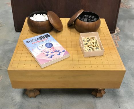 An early 20th Century goban game board, on legs, together with goset including china bamboo effect bowls, instruction book an