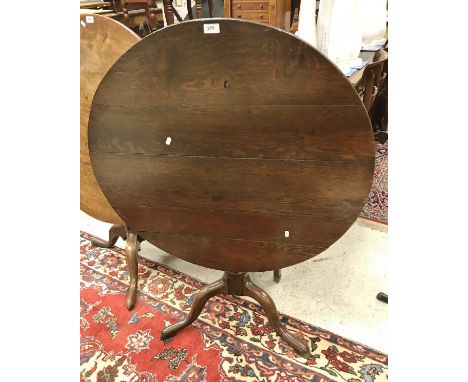 A 19th Century oak tea table, the circular snap top on a baluster turned pedestal to cabriole tripod base 