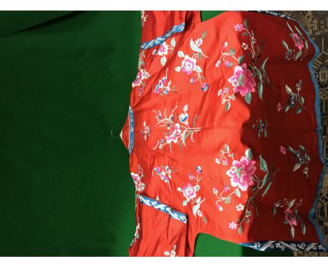 A Chinese red silk jacket with all over decoration of floral sprays and insects