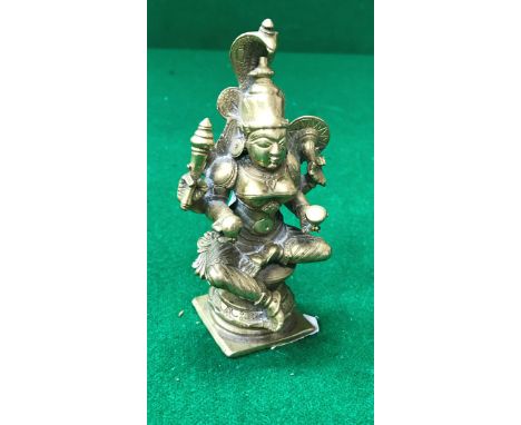 A 19th Century Indian cast bronze figure of a seated four armed deity
