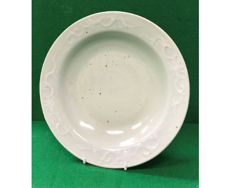 An 18th Century Chinese celadon glazed dish with white slip scroll work decoration, raised on a circular foot CONDITION REPOR