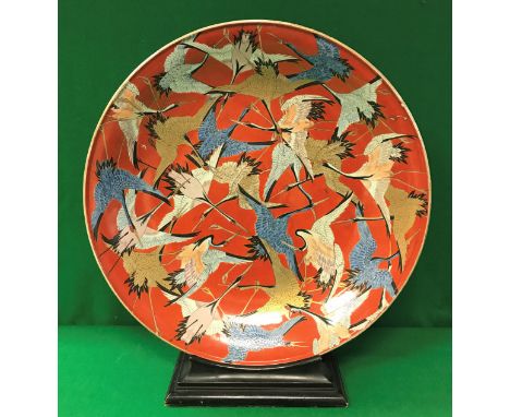 A 19th Century Japanese Meiji Period porcelain charger, polychrome decorated with hooded cranes in flight with scrollwork und