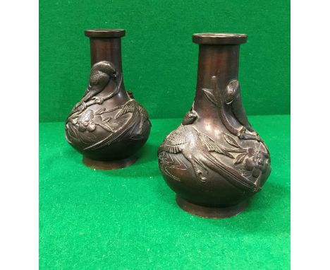 A pair of circa 1900 Chinese bronze baluster shaped vases chocolate patinated and decorated in relief with birds amongst blos