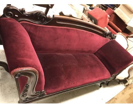 A Victorian carved mahogany framed scroll arm sofa on octagonal faceted baluster supports to castors 