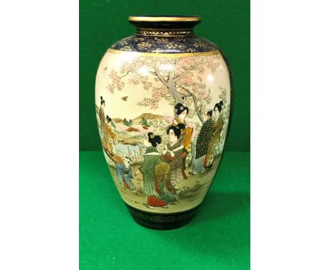 An early 20th Century Japanese Satsuma ware vase decorated with panels of figures in a garden setting on a deep blue and gilt