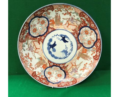 A 19th Century Japanese Imari charger decorated with panels of figures in garden settings and flowers