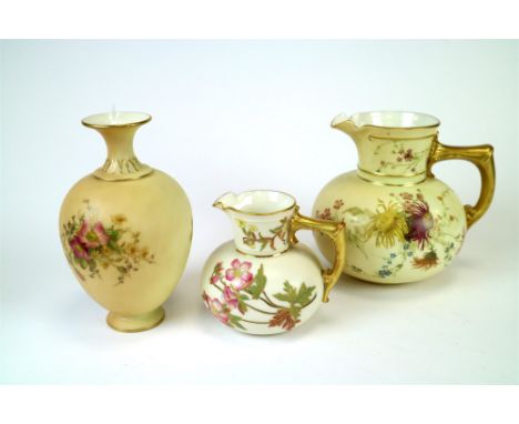 Three pieces of blush ivory Royal Worcester porcelain, including a large bulbous jug with floral motifs and gilded handle, pu