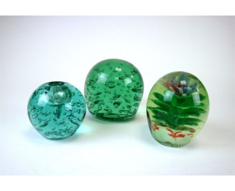 A collection of Victorian green glass dumps and paperweights, to include two large and two smaller bottle green dumps with en