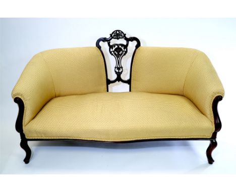 A late Victorian mahogany sofa with central pierced vase shaped splat back later upholstered in gold coloured fabric above a 