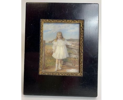 An early 20th century portrait miniature of a girl standing against a gate, 9.3cm x 6.3cm 