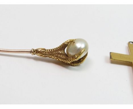 A talon clutching a pearl stickpin, the pearl untested and unwarranted; with a garnet set stickpin; a silver cross; and a met