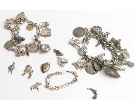 A silver charm bracelet with various charms attached to include a St Christopher, a spinning 'Good Luck', compass and others;