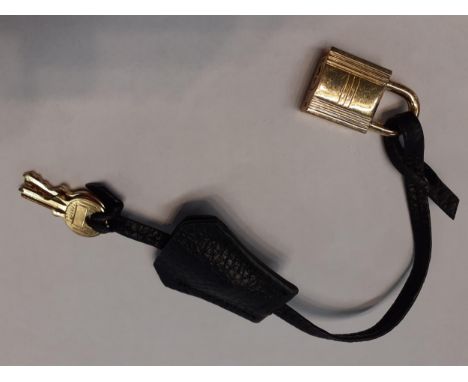 Hermes-A late 20th Century black leather fob on leather strap having gold tone hardware and 2 keys. Location:Cab 