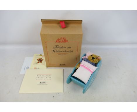 Steiff - A boxed Steiff 'Limited Edition' #037948 'Teddy Bear with a Cloud Cradle'. The light brown 14cm bear comes with Stei