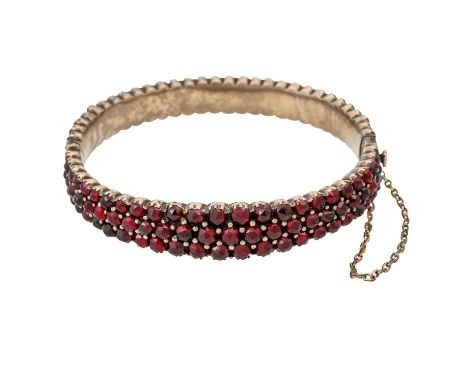   Armreif mit Granat,  Metall vergoldet, Innenumfang 17,5 cm, um 1900, altersgemäß leichte Tragespuren.  Bangle with garnet, 