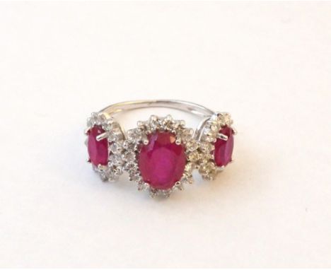 RUBY AND CZ TRIPLE CLUSTER RING
by L'Azurde, each of the graduated oval cut rubies in CZ surround, on eighteen carat white go