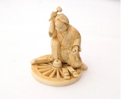 JAPANESE CARVED IVORY FIGURE OF A WHEELWRIGHT
with tools and kneeling on wheel, signed to base, 8cm high