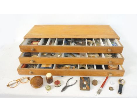 BOX OF WATCH PARTS AND TOOLS
including movements, dials, straps, cases, pliers and other tools, all contained in a three draw