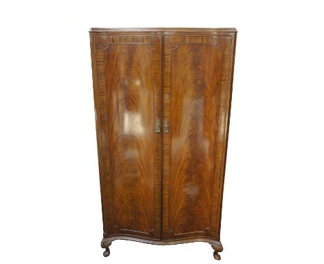 BEITHCRAFT MAHOGANY SERPENTINE WARDROBE
with panelled doors opening to reveal a fitted interior and trade label, standing on 