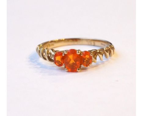 GRADUATED FIRE OPAL THREE STONE RING
on nine carat gold shank with decorative spiral effect shoulders, ring size S