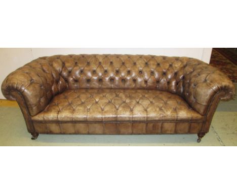 CHESTERFIELD SOFA, Victorian, in distressed brown leather on turned supports, 87cm D x 208cm W x 72cm H. 