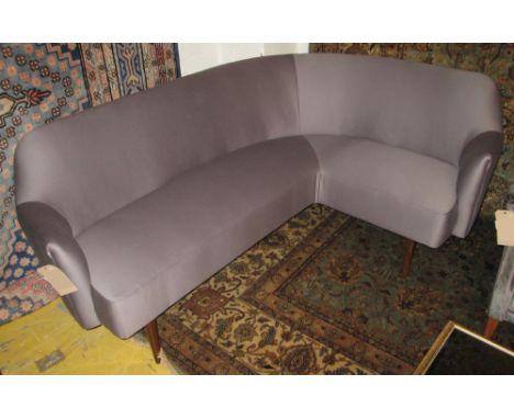 CORNER SOFA, Danish, 1950's, of curved form, newly upholstered in dark lilac on beech tapering supports, 185cm W x 135cm D x 