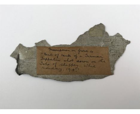 A fragment of First World War German Zeppelin fuselage, with paper label bearing the inscription 'Part of tank of a German Ze