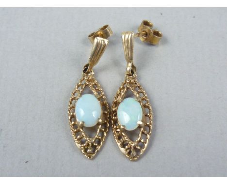 A vintage pair of 9ct gold and opal ear pendants, each of lenticular form, and centrally claw set with an opal cabochon of ap