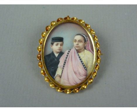 An early 20th Century yellow-metal double pendant locket brooch containing a portrait miniature of an Indian lady and young s